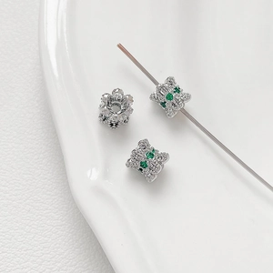 Macro shot of silver spacer beads with cat and floral shapes for DIY jewelry making