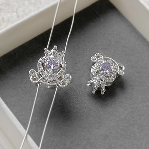 Macro shot of silver carriage charm with a purple heart zircon and micro-pave crown detail
