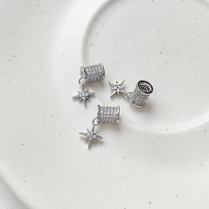 Macro view of three silver 18k gold-plated star charms with pavé set zirconia stones