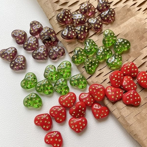 Close-up of heart-shaped glass beads with gold polka dots for DIY jewelry making