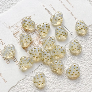 Macro detail of heart-shaped glass beads with gold dots for DIY jewelry making