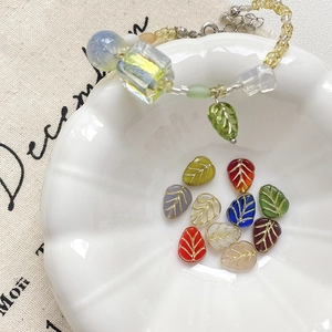 Détail de perles en verre feuille faites main avec bordure dorée dans un bol chic