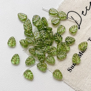 Gros plan de perles en verre feuille verte avec nervures dorées pour bijoux