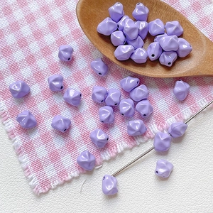 Detalle de cuentas irregulares de resina lavanda con agujero central para crear joyería