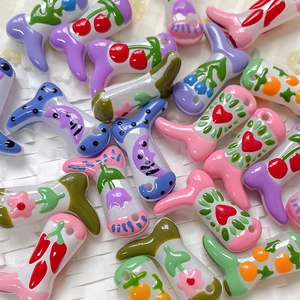 Detailed view of colorful hand-painted boot-shaped glass beads for DIY jewelry making