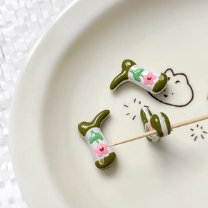 Macro shot of boot-shaped glass beads with floral patterns for jewelry making