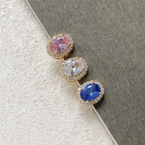 Macro detail of 18k gold-plated oval faceted gemstones with micro-inlaid halo setting