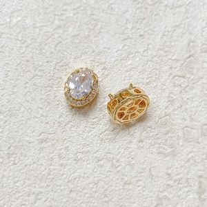 Detailed macro view of 18k gold-plated oval zircon beads showing stone setting and back