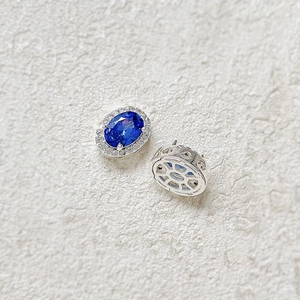 Macro shot of 18k gold-plated oval blue gemstones with halo diamonds and hollow details