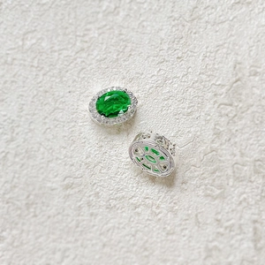 Detailed close-up showing the front and back of green oval emerald earrings with zircon halo