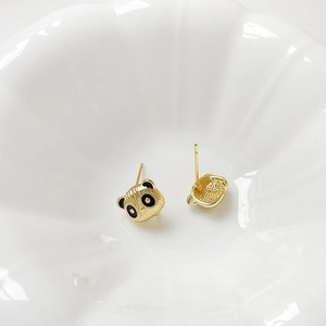 Makro-Detail von 18k vergoldeten Panda-Ohrsteckern mit schwarzer Emaille auf Keramik
