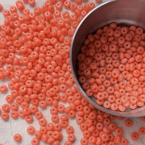 Macro shot of 4mm coral orange glass seed beads for DIY jewelry and beaded necklaces