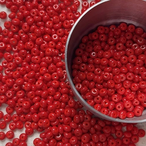Macro shot of 4mm bright red glass seed beads for DIY jewelry and beaded crafts