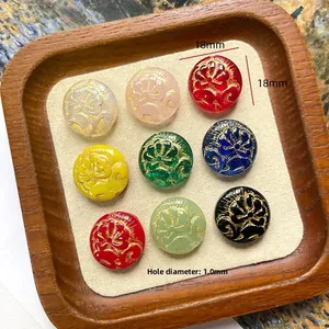 Detail of 18mm vintage floral relief beads with gold accents on a wooden display tray