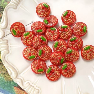 Macro detail of red and gold hand-painted cherry glass beads for DIY jewelry making