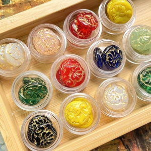 Macro view of vintage peony carved beads with gold trim in assorted vibrant colors