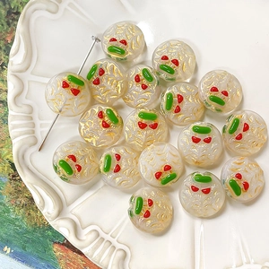 Macro detail of hand-painted cherry glass beads with gold foil for DIY jewelry making