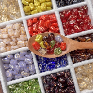 Colorful glass tulip beads for DIY jewelry making displayed on a white velvet tray