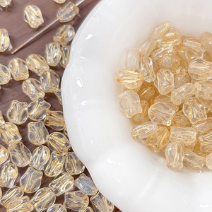 Detailed macro of tulip glass beads with gold sand texture for DIY jewelry making