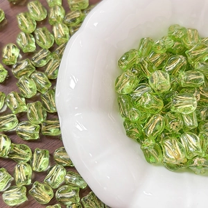 Detail of green tulip-shaped glass beads with gold texture for DIY jewelry making