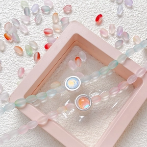 Frosted gradient bead bracelets with aurora pendants on white textured background