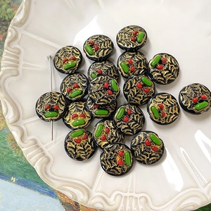 Macro view of hand-painted cherry glass beads with gold texture for DIY jewelry