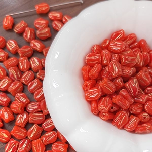 Macro shot of red tulip glass beads with gold trim for handmade DIY jewelry crafts