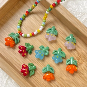 Handmade colorful glass tulip flower beads and beaded necklace on a wooden tray