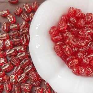 Macro detail of red tulip glass beads with gold wire drawing for DIY jewelry making