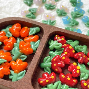 Macro view of colorful tulip-shaped glass beads for DIY jewelry in a wooden tray
