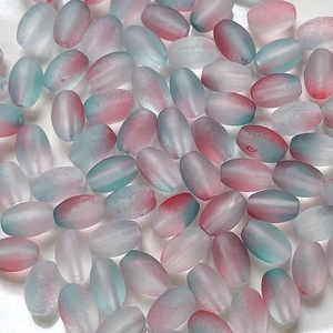 Flat lay of oval frosted beads with pink and teal gradient for DIY jewelry making