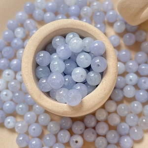 Makroaufnahme von natürlichen Aquamarin-Rundperlen mit Mittelloch in Keramikschale