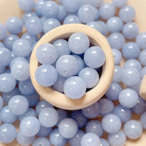 Makro-Detail natürlicher Aquamarin-Perlen mit Bohrung in einer Holzschüssel