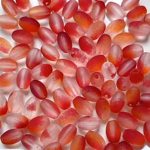 Macro shot of oval gradient frosted red beads with precision drill holes for DIY jewelry