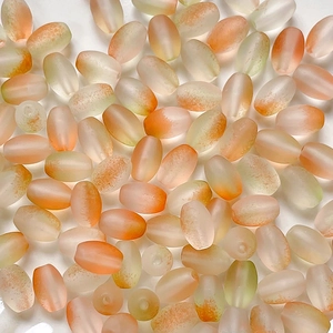 Macro shot of oval frosted gradient beads in warm orange and beige for DIY jewelry