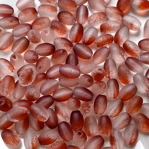 Macro shot of oval frosted glass beads with gradient reddish-brown to white DIY textures