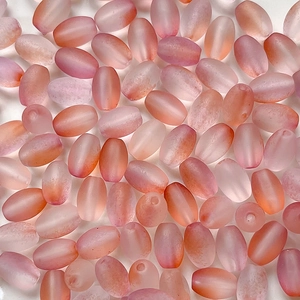 Macro detail of frosted oval beads with pink and orange gradient for DIY jewelry making