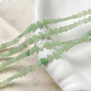 Primer plano de cuentas de piedra natural verde pálido con forma de estrella para DIY