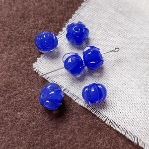 Primer plano de cuentas de vidrio azul oscuro en forma de capullo para joyería DIY