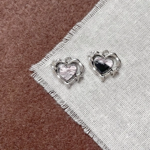 Dettaglio di ciondoli a cuore DIY con texture in marmo rosa e finitura in resina nera