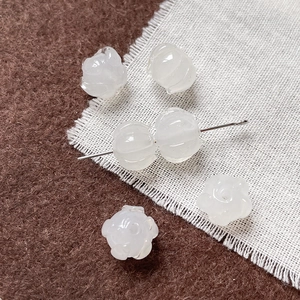 Vista macro de cuentas en forma de capullo de loto blanco con textura de jade para joyas DIY