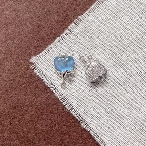 Dettaglio di pendenti a cuore argento con design fluido blu e texture a stella