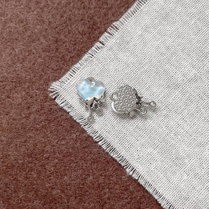 Dettaglio macro del ciondolo a cuore in argento con intarsio azzurro ed effetto metallo liquido