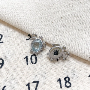 Vue macro de breloques tortue avec pierre bleue et métal argenté pour bijoux DIY
