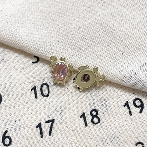 Macro d'un pendentif tortue en alliage avec zircon rose et finition dorée élégante