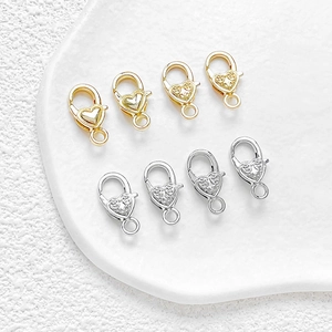 Dettaglio dei fermagli a moschettone a cuore in oro e argento per la creazione di gioielli