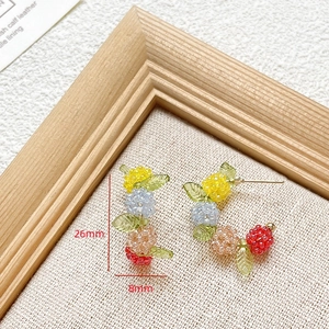 Detailed close-up of handmade multi-colored beaded C-shaped stud earrings, size 26x8mm