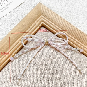 Detailed size view of beaded bow charm in pink and white with 9.2cm width and 6.2cm height