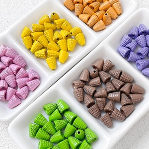 Colorful resin waffle cone beads with LOVE engraving in a white ceramic tray