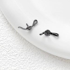 Détail macro d'une bélière noire avec tige filetée pour bijoux en perles baroques